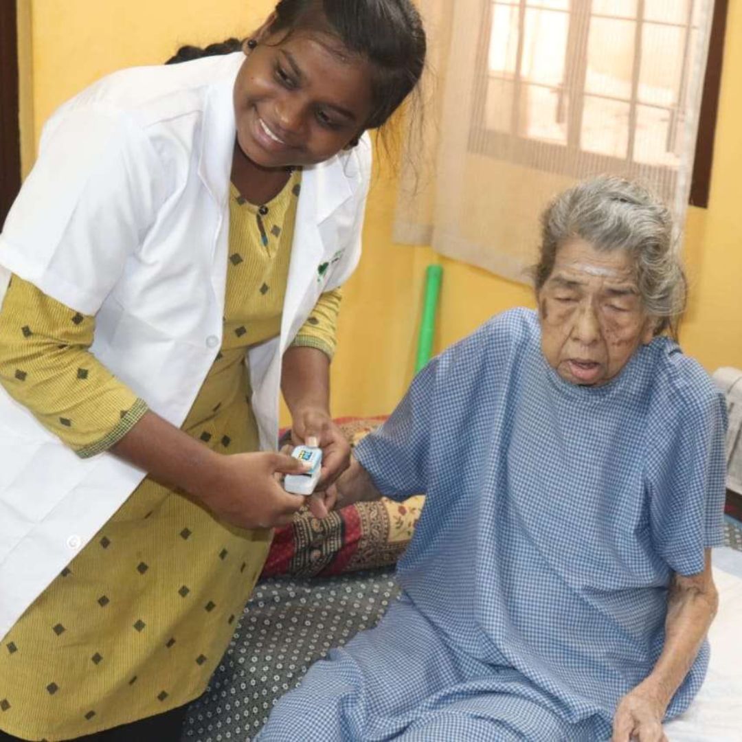 Doctor from Lucky Home Health Care examining an elderly patient during a home visit in Chennai.